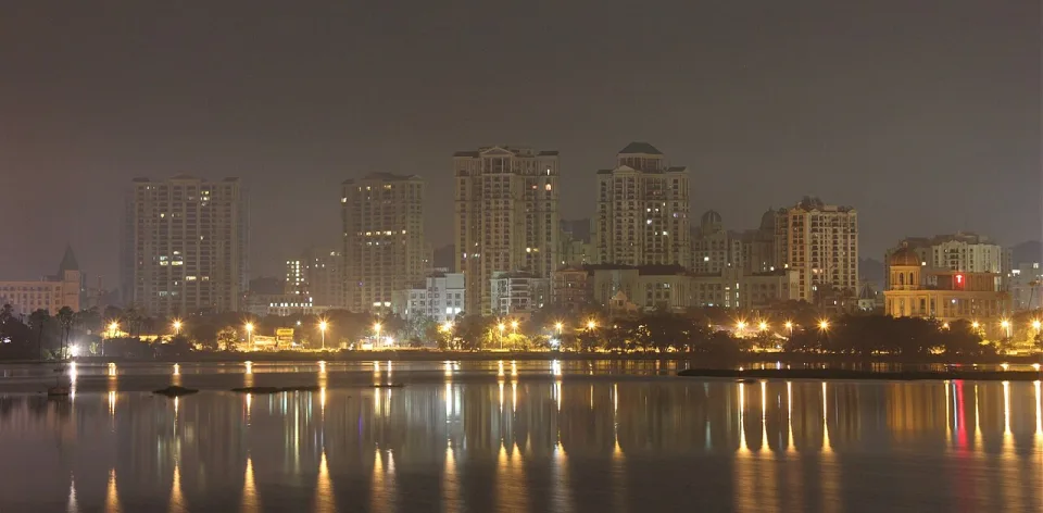 Hiranandani Gardens towers lit up at night across Powai Lake